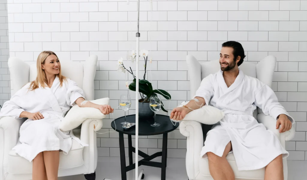 A couple enjoying an IV therapy session in a luxurious lounge.