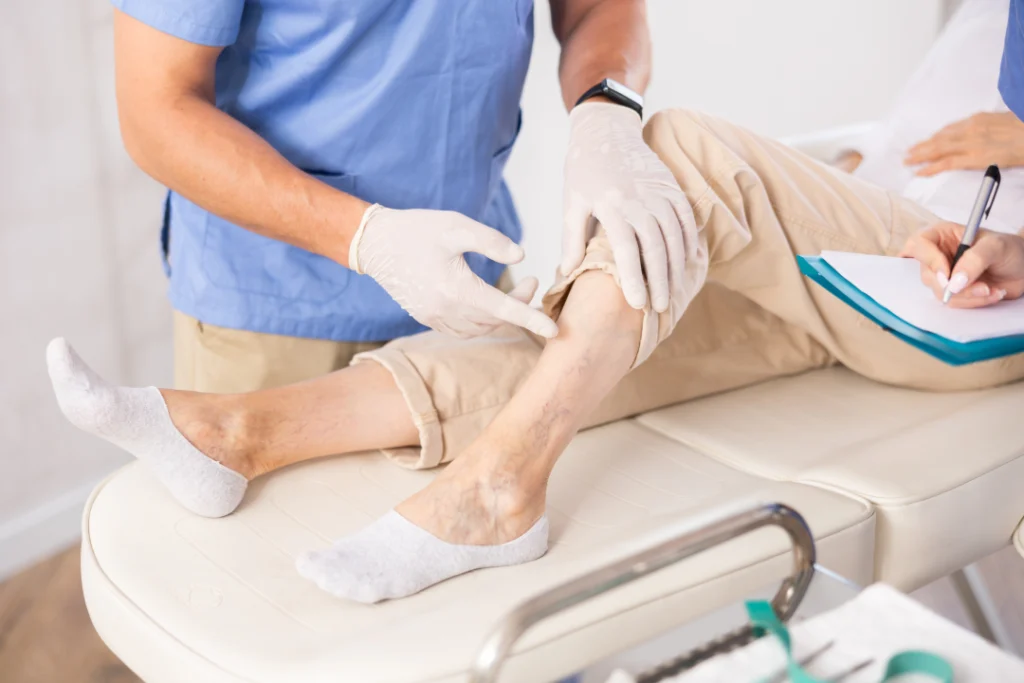 A doctor examines a patient's leg for spider veins.