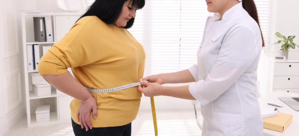 Healthcare professional measuring a patient's waist during a medical weight loss program.