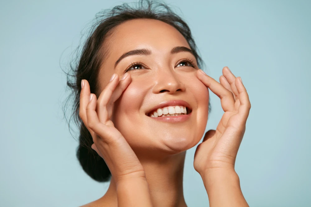 Woman touching glowing skin after HydraFacial.